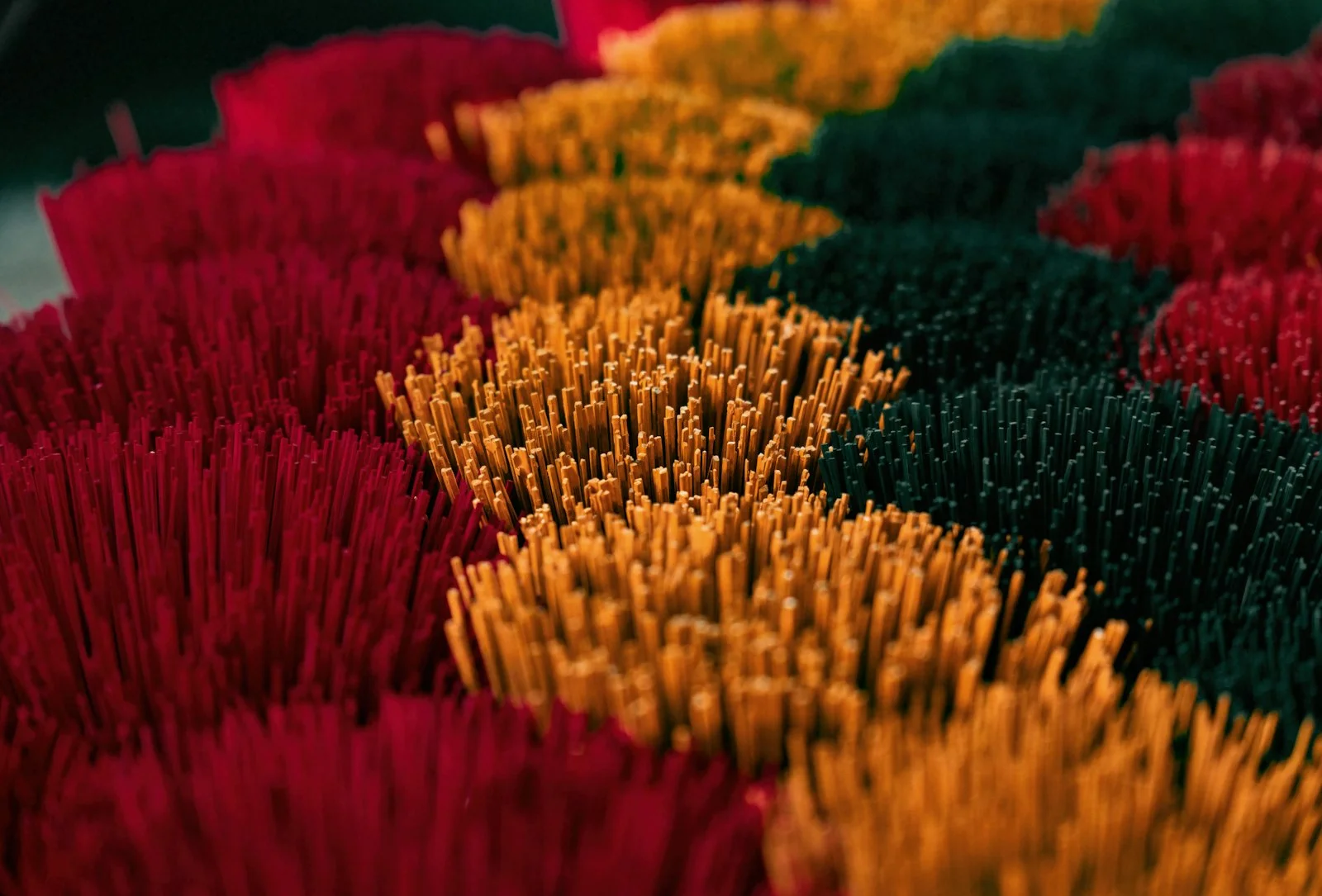 Rows of vibrant red, yellow, and green incense sticks.