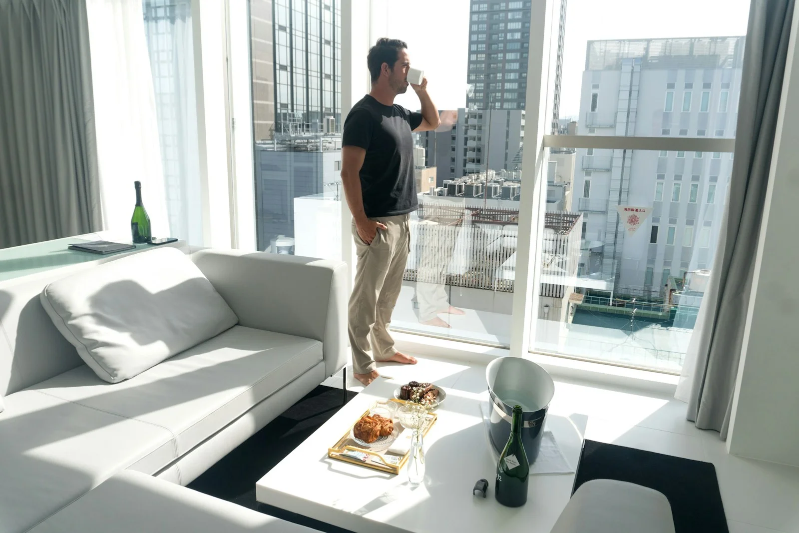 A man standing in a living room next to a window A man standing in a living room next to a window
